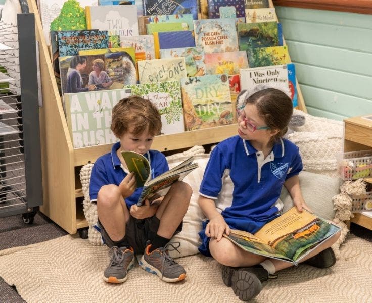 Two students sitting in the bright and welcoming reading area of the classroom.
