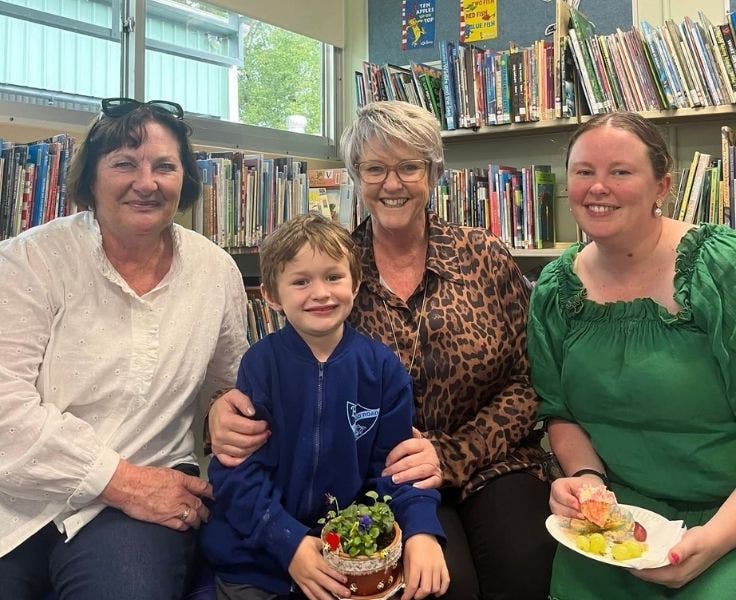 Student surrounded by his mother and grandmothers, enjoying the mother's day pamper session.